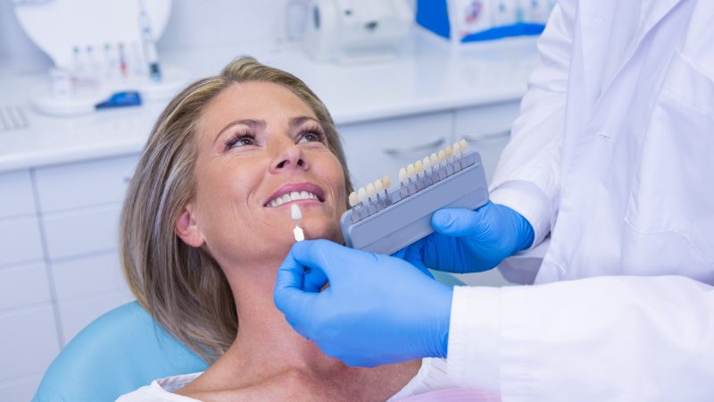 doctor-holding-tooth-whitening-equipment-by-patient.jpg